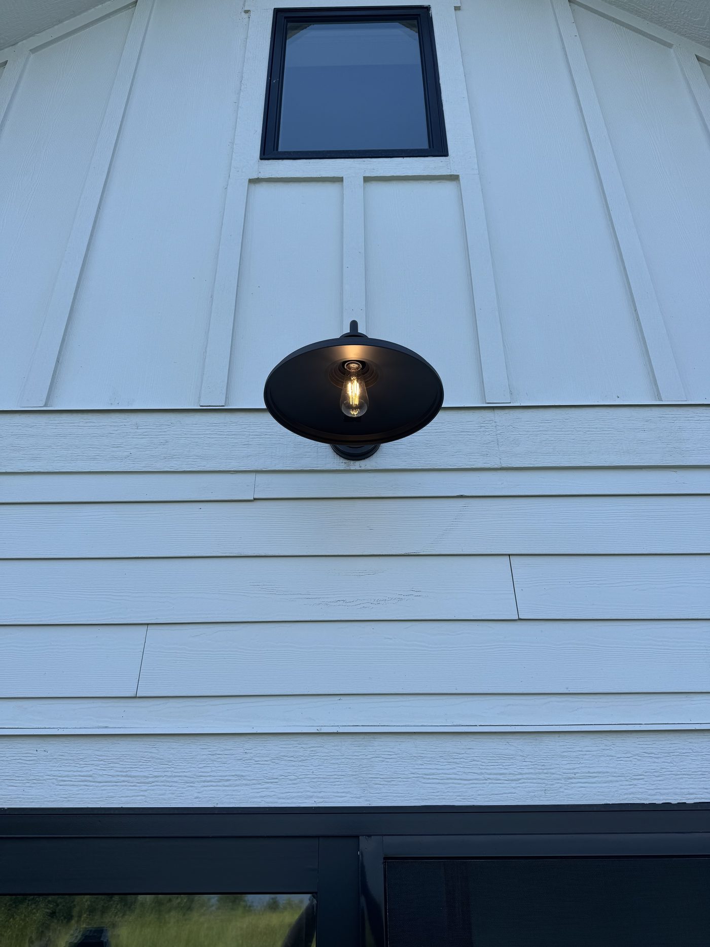 Exterior barn-style light fixture installed on a home